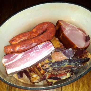 Image of the pork used for feijoada in a pot, chorizo, bacon, hocks and jamon
